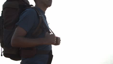 Cropped-shot-of-male-backpacker-standing-at-cliff