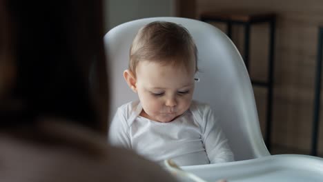 Video-of-mom-feeding-baby-girl-in-high-chair.