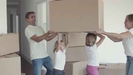 Family-couple-and-two-girls-moving-into-apartment
