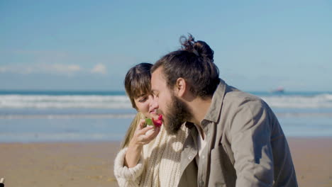 Glückliches-Paar,-Das-Wassermelone-Am-Strand-Isst
