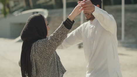 Romantisches-Muslimisches-Paar,-Das-An-Einem-Sonnigen-Tag-Draußen-Tanzt.