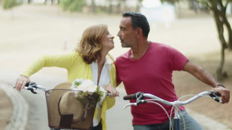 Mittlere-Aufnahme-Eines-Kaukasischen-Paares,-Das-Auf-Fahrrädern-Sitzt-Und-Sich-Küsst