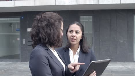 Erfolgreiche-Geschäftsfrauen-Diskutieren-Projekt-Auf-Tablet-Bildschirm