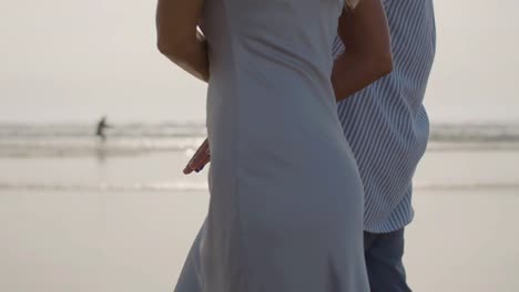 Closeup-of-romantic-Caucasian-couple-walking-along-the-beach.