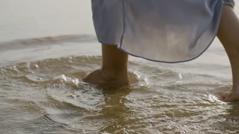Legs-closeup-of-woman-with-red-nails-walking-in-sea-water.