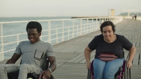 Glückliches-Paar,-Das-Rollstühle-Benutzt,-Die-Auf-Der-Brücke-Rennen