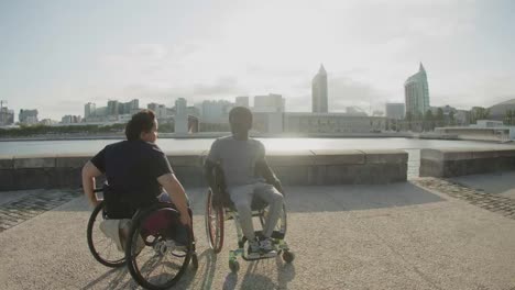 Glückliches-Paar,-Das-Rollstühle-Benutzt-Und-Wellenbewegungen-Am-Kai-Macht