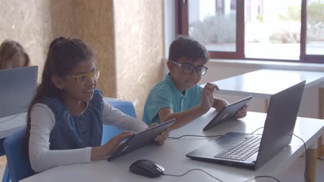 Positive-school-children-in-glasses-doing-task