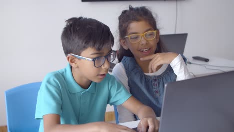 Couple-of-schoolchildren-in-glasses-working-on-task