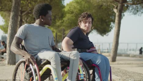 Happy-young-couple-dancing-using-wheelchairs-in-park