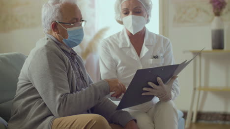 Doctor-holding-clipboard-with-documents-and-talking-with-patient