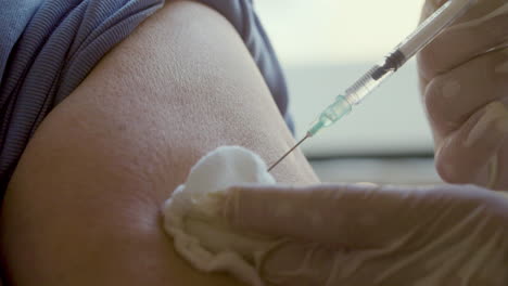 Close-up-shot-of-syringe-with-injection-inserting-into-arm