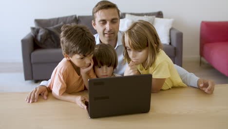 Dad-and-three-sibling-kids-using-laptop-for-video-call
