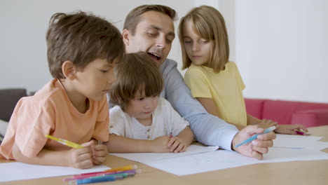 Fürsorglicher-Vater-Und-Nette-Kinder,-Die-Mit-Marker-Auf-Papier-Zeichnen