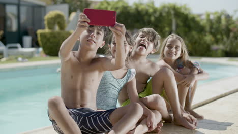 Boy-making-selfie-of-himself-and-his-friends-on-poolside.