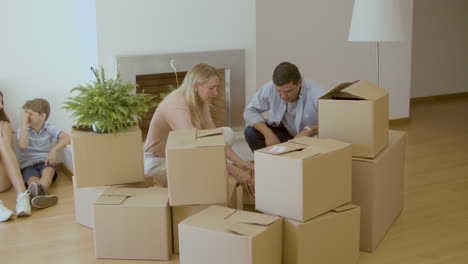 Man-and-woman-taking-things-out-of-carton-boxes-after-moving