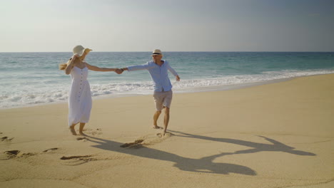 Happy-couple-walking-together-on-beach