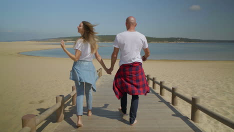 Barefoot-couple-walking-together-on-beach