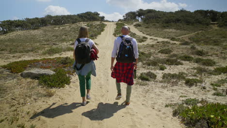 Back-view-of-couple-with-backpacks-walking-outdoor