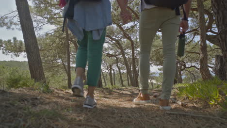 Couple-of-backpackers-holding-hands-and-walking-outdoors