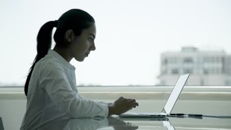 Focused-young-businesswoman-using-laptop
