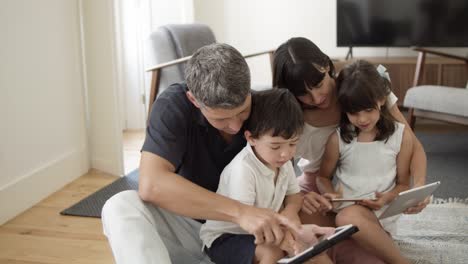 Glückliches-Familienpaar-Und-Zwei-Kinder-Mit-Digitalen-Tablets