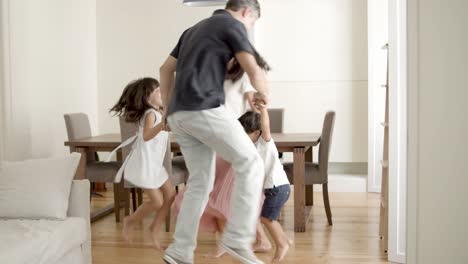 Fröhliche-Eltern-Und-Kinder,-Die-Zu-Hause-Aktive-Spiele-Spielen