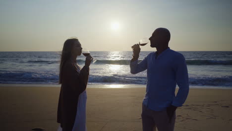 Couple-drinking-wine-and-kissing-on-beach
