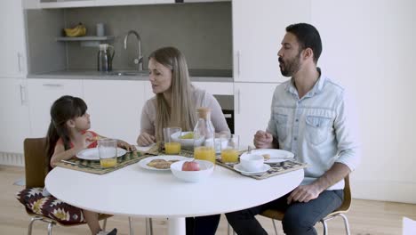 Parents-couple-and-little-girl-having-breakfast-together