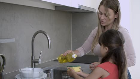 Cute-girl-helping-her-mom-to-wash-dish