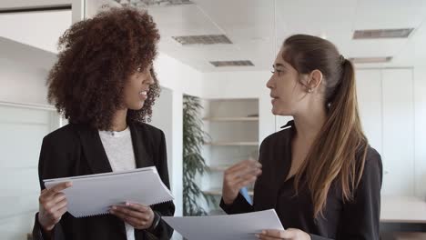 Weibliche-Geschäftskollegen-Halten-Und-Diskutieren-Papier