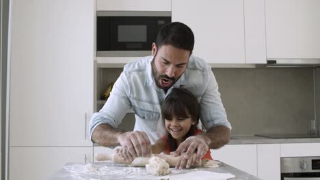 Happy-dad-and-little-daughter-rolling-dough