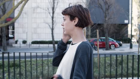 Side-view-of-nervous-woman-walking-and-talking-on-smartphone