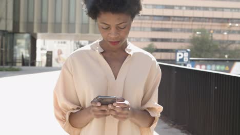 Ruhige-Afroamerikanische-Frau,-Die-Ihr-Smartphone-Benutzt