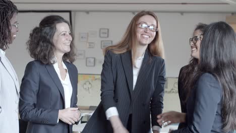 Mujeres-Empresarias-Sonrientes-Dándose-La-Mano-En-La-Oficina