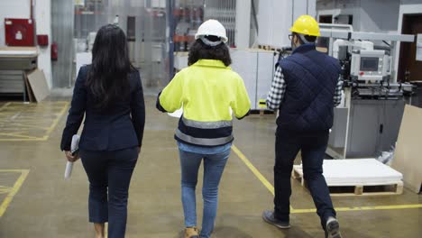 Back-view-of-factory-workers-walking-at-plant