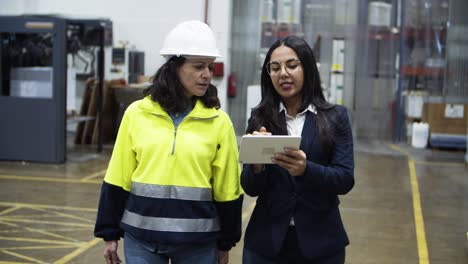 Concentrated-project-manager-and-technician-walking-with-tablet