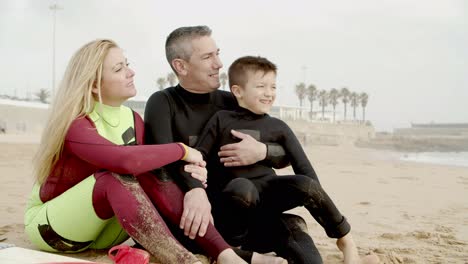 Happy-family-sitting-and-talking-on-beach