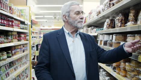 Mature-man-with-shopping-basket-in-grocery-store