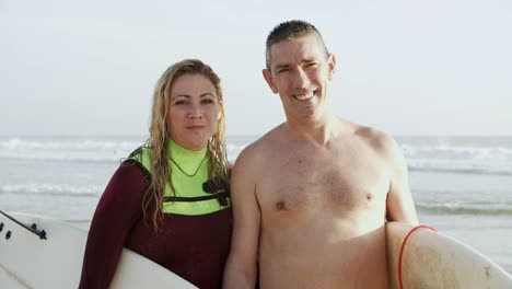 Couple-of-surfers-smiling-at-camera