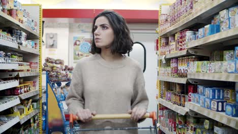 Young-woman-looking-at-shelves-in-grocery-store