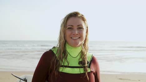 Happy-female-surfer-smiling-at-camera