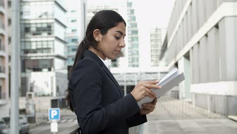Young-focused-businesswoman-reading-papers