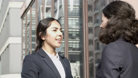 Confident-businesswomen-talking-on-street