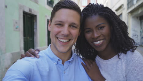 Happy-multiracial-couple-posing-for-selfie-outdoor.
