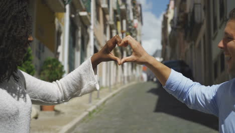 Smiling-young-couple-making-heart-shape-with-hands.