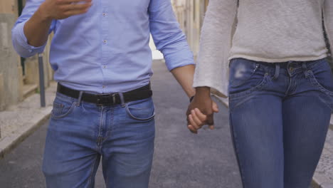 Cropped-shot-of-multiracial-couple-holding-hands-together.