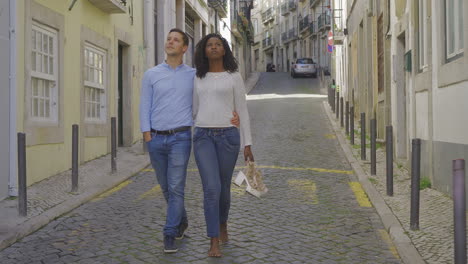 Relaxed-young-couple-walking-on-old-city-street.