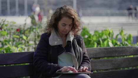 Fokussierte-Reife-Frau,-Die-Im-Freien-Ein-Tablet-Verwendet