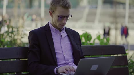 Focused-businessman-in-eyeglasses-using-laptop